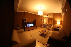 a living room with couches and a tv and a table at Yücemek Apart in Hurmaköy