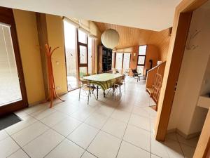 a dining room with a green table and chairs at Gîte du Kiwi in Luttenbach-près-Munster