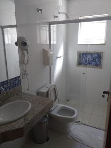 a bathroom with a toilet and a sink and a shower at Avenida Palace Hotel in Mariana