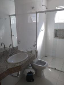ein weißes Bad mit einem Waschbecken und einem WC in der Unterkunft Avenida Palace Hotel in Mariana