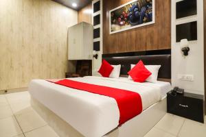 a bedroom with a large bed with red pillows at Hotel Sheela in Rohtak