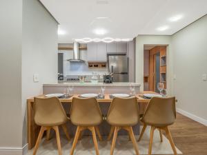 a kitchen with a dining room table and chairs at Delle Alpi 111B - Ao lado da Roda-Gigante in Canela