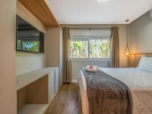 a bedroom with a bed and a window at Delle Alpi 111B - Ao lado da Roda-Gigante in Canela