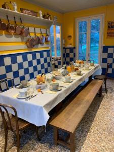 una mesa larga con platos de comida. en LE CLOS DU TULIPIER en La Chapelle-du-Bard