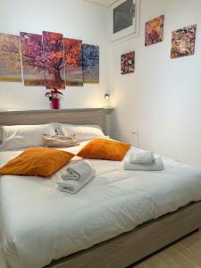 a bed with orange and white pillows on it at Tourist House Bologna Pratellino - Self Check-in in Bologna