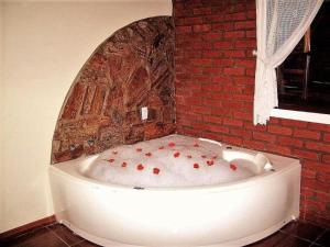 a bath tub with blood on it next to a brick wall at Pousada Amor Perfeito in Visconde De Maua