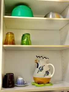 ein Regal mit einer Teekanne und anderen Artikeln darauf in der Unterkunft Tourist House Bologna Pratellino - Self Check-in in Bologna