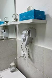 ein Haartrockner an der Wand eines Badezimmers in der Unterkunft Tourist House Bologna Pratellino - Self Check-in in Bologna