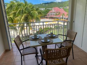 a table and chairs on a balcony with a view of the beach at Village Ste luce - Olivera Studio in Sainte-Luce