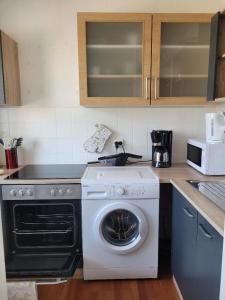 eine Küche mit einer Waschmaschine und einer Mikrowelle in der Unterkunft Marcel's Appartement in Bielefeld