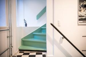 a hallway with stairs with blue and green at The Townhouse by Daniel&Jacob's in Copenhagen