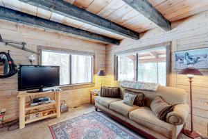 a living room with a couch and a flat screen tv at Totorica Cabin in McCall