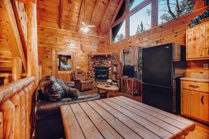 a living room with a wooden cabin with a table and a refrigerator at Sugar Bear Cabin in Sevierville