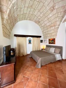 1 dormitorio con 1 cama con techo de piedra en Villa Emanuel, en Alessano