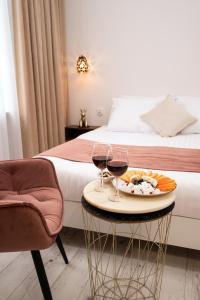 una camera d'albergo con vassoio di cibo e due bicchieri di vino di Hive Family House a Cracovia