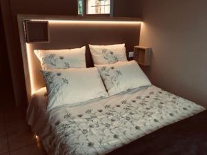 uma cama com lençóis e almofadas azuis e brancos em Le Chalet de la REPANDISE em Laveline-du-Houx