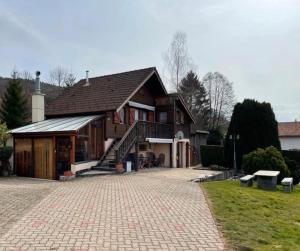 uma casa com uma entrada de tijolos em frente em Le Chalet de la REPANDISE em Laveline-du-Houx