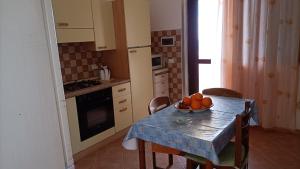 a kitchen with a table with a bowl of fruit on it at LA FINESTRA SUL MARE PIANO Terra in Trappeto