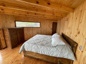 a bedroom with a bed in a wooden cabin at Casa al mare uno - Matanzas y Pupuya in Navidad
