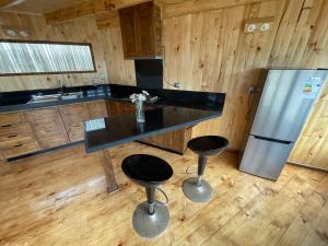 a kitchen with a counter and a refrigerator and stools at Casa al mare uno - Matanzas y Pupuya in Navidad +4 photos