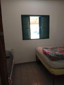 a small room with a bed and a window at Casa - Sítio da Tabi - Lagoinha-SP in Lagoinha