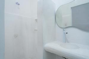 uma casa de banho branca com um lavatório e um espelho em Italia Estación Hotel, Merida em Mérida