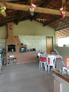 a kitchen with a table and chairs and a fireplace at Casa - Sítio da Tabi - Lagoinha-SP in Lagoinha