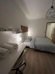 ein weißes Schlafzimmer mit einem Bett und einem Schreibtisch in der Unterkunft Apartment - Place Jourdan & EU institutions in Brüssel