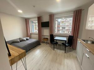 a bedroom with a bed and a table and a kitchen at Apartamenty Wisła Centrum in Wisła