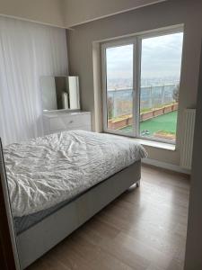 um quarto com uma cama e uma grande janela em MediKule em İkitelli