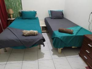 two beds in a room with blue sheets and pillows at In The Heart Of Praia - Family B&B in Praia