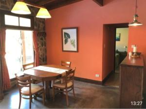 uma sala de jantar com uma mesa de madeira e cadeiras em Casa El Cobijo em Tandil