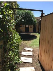 um jardim com um portão de madeira e uma cerca em Casa El Cobijo em Tandil