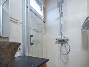 a shower with a glass door in a bathroom at Appartement rénové au cœur de l'Alpe d'Huez avec Wifi et Parking - FR-1-645-24 in LʼHuez +8 photos