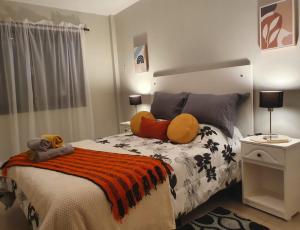 a bedroom with a large bed with orange pillows at Marfil in Posadas