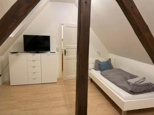 a attic bedroom with a bed and a tv at Fewo Alte Schule in Willingen
