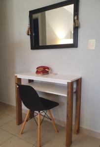 escritorio con silla y espejo en la pared en Marfil en Posadas