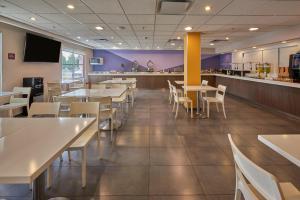 a restaurant with tables and chairs and a counter at Sierra Suites By HP Hotels in San Luis Potosí