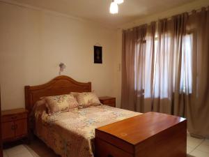 1 dormitorio con cama, mesa y ventana en Casa Guevara en San Rafael