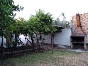 una casa con garaje y árboles en el patio en Casa Guevara en San Rafael