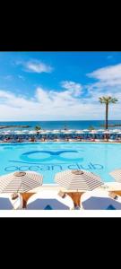 una gran piscina con sillas y el océano en Heart of Puerto Banus newly renavated Free parking , WIFi ,Pool,Gym,Padel court, en Marbella