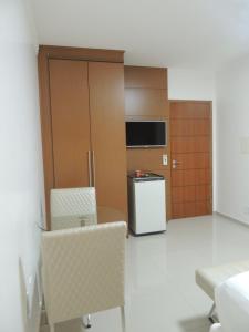 Zimmer mit einem Tisch, Stühlen und einem Kühlschrank in der Unterkunft Star Hotel in Itaperuna