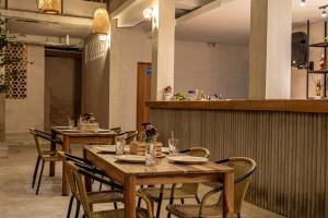 a restaurant with wooden tables and chairs and a bar at Soy Local Santa Marta in Santa Marta