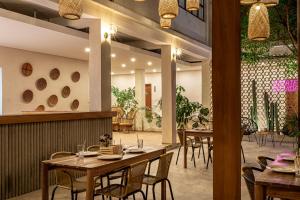 a restaurant with wooden tables and chairs and plants at Soy Local Santa Marta in Santa Marta +68 photos
