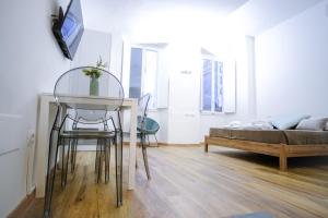 a living room with a table and chairs and a bed at Le Dantesche Boutique Apartments in Florence