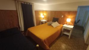 Habitación de hotel con 1 cama y 2 mesitas de noche en Lomas del Uritorco - Casa de Alq x Temp en Capilla del Monte