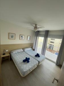 a bedroom with a bed with blue pillows on it at Edificio Albires in Albir