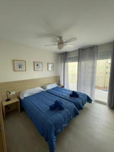 ein großes blaues Bett in einem Schlafzimmer mit einer Decke in der Unterkunft Edificio Albires in Albir