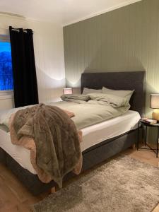 Un dormitorio con una cama con una manta. en Beautiful view - close to the sea, mountains and nature en Kvaløya
