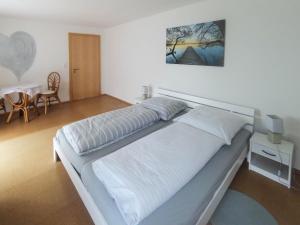 Ferienwohnung im bayerischen Wald في Tittling: سرير كبير في غرفة مع طاولة